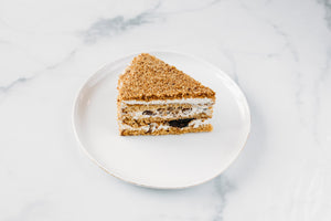 Rebanada de pastel de miel con ciruelas pasas y nueces
